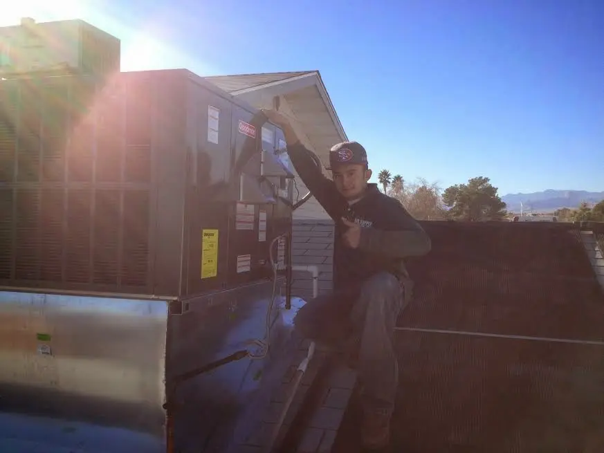 HVAC technician performing Air Duct Repair on a rooftop unit in Bonney Lake